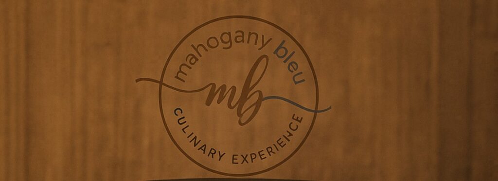 Mahogany Bleu Culinary Experience logo on wood.