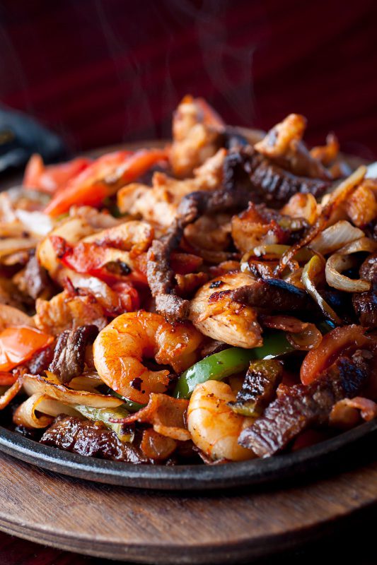 A colorful plate of shrimp and beef stir-fry with vegetables.