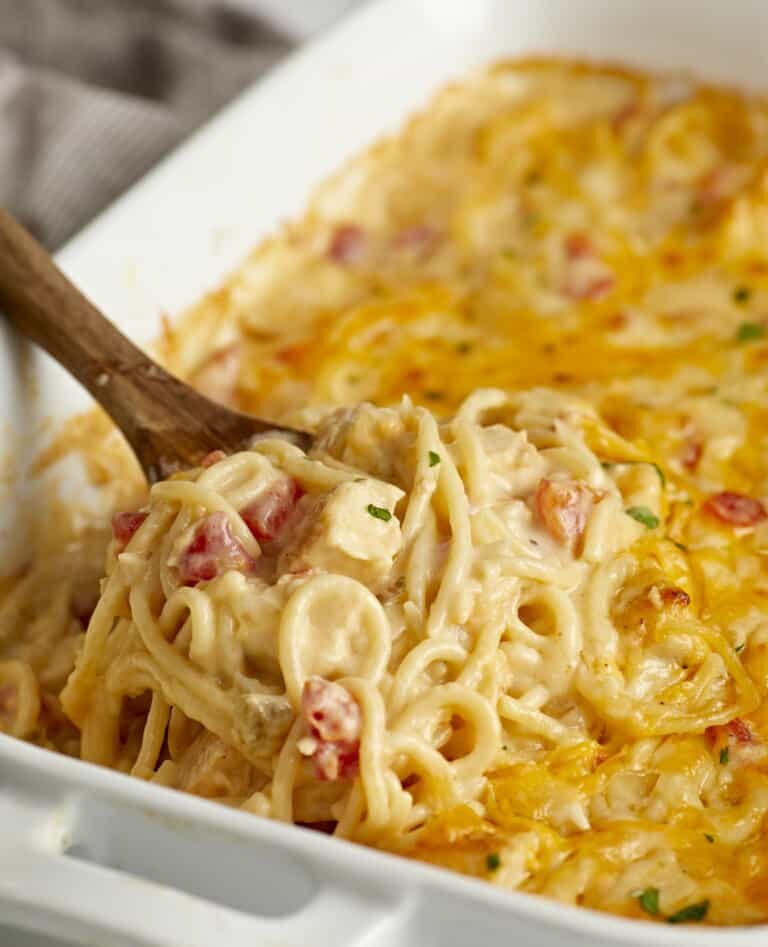 Creamy cheesy pasta bake with vegetables being served.