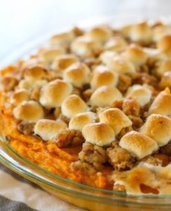 A sweet potato casserole topped with toasted marshmallows and a crumbly nut topping.