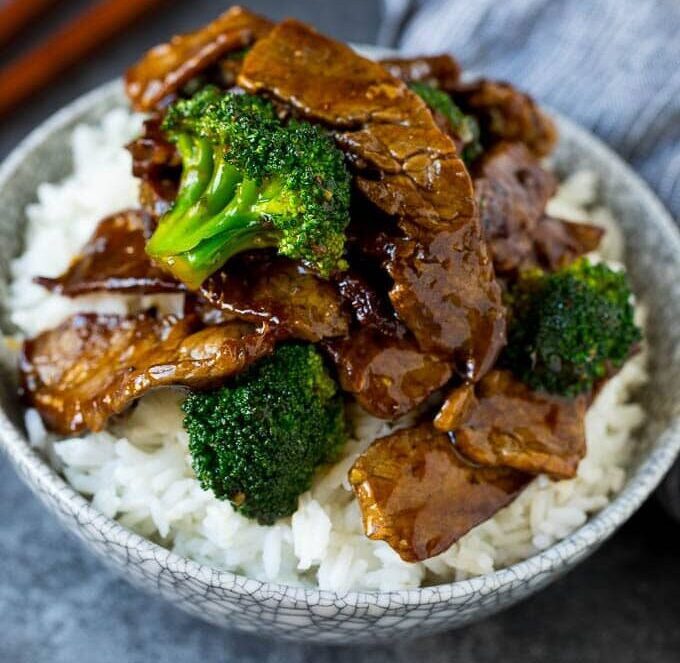 Beef and broccoli served over white rice in a bowl.
