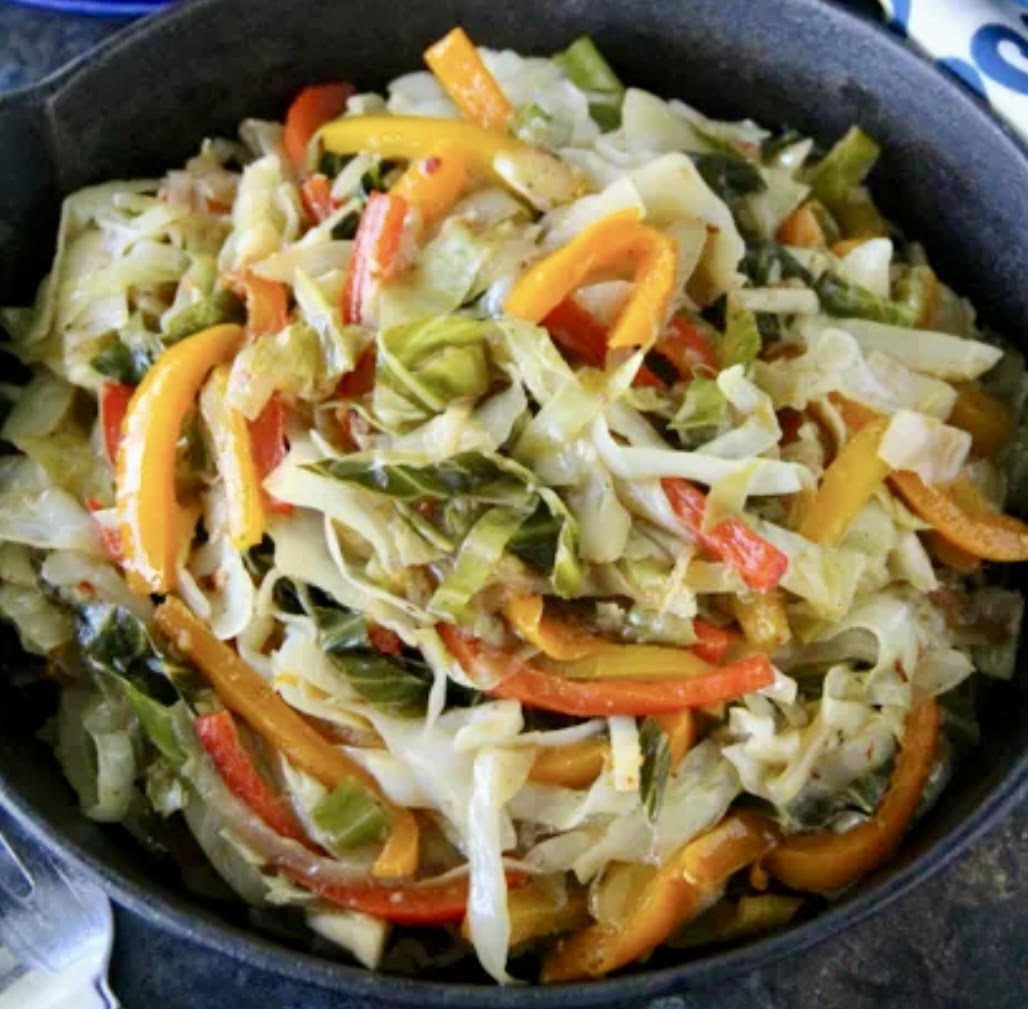 Colorful sautéed cabbage and bell peppers in a skillet.