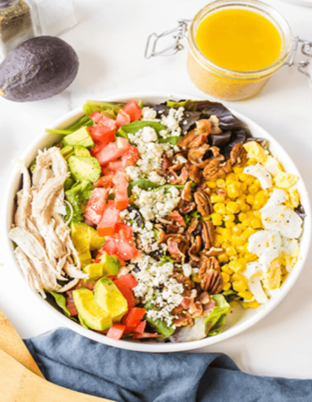 Colorful salad with chicken and various toppings.